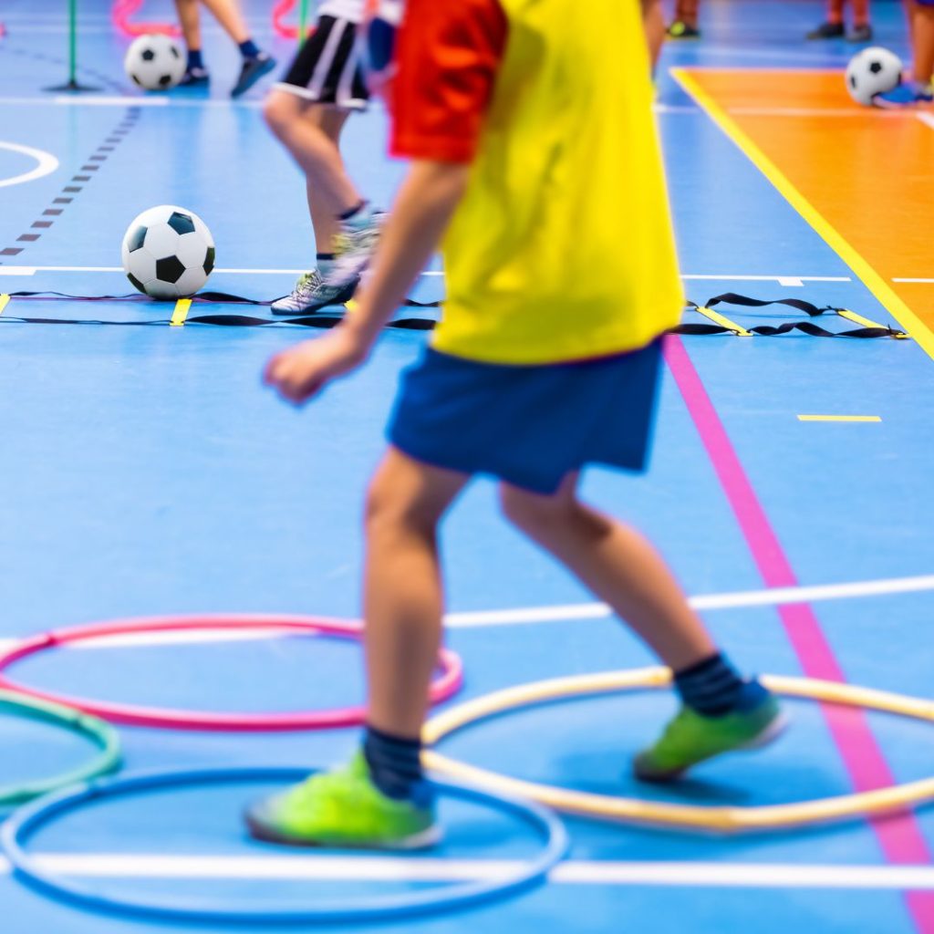 A picture of a child's feet in hoops on a a gym floor.